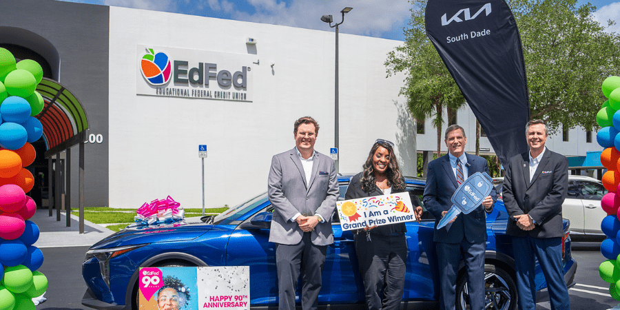 Carolyn Moss standing next to three EdFed employees in front of a 2025 Kia K4.