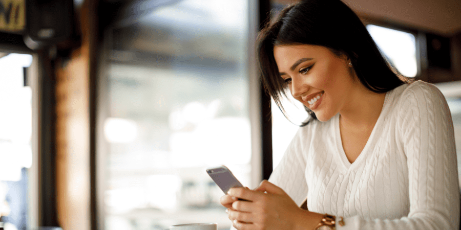 A woman using her smart phone in a coffee shop.