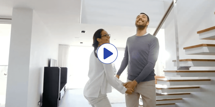 Video thumbnail of a young couple holding hands under the stairs of their home.