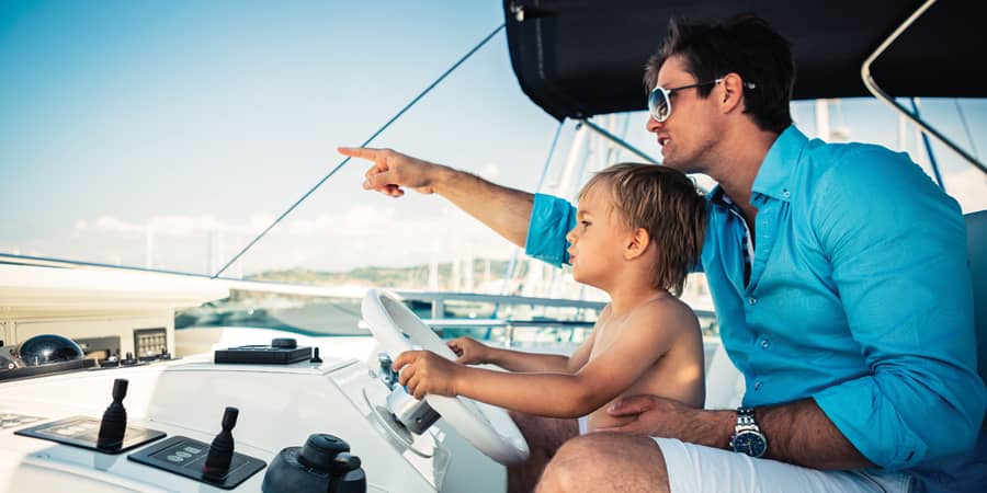 A father and son fishing on a boat.