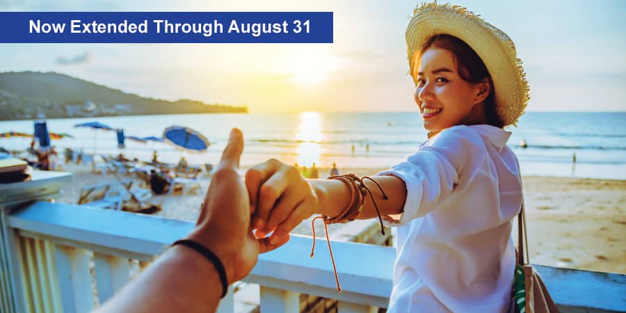 A young woman standing on a balcony looking over the shoreline during a beautiful sunset. At the top, the words: Now extended through August 31.