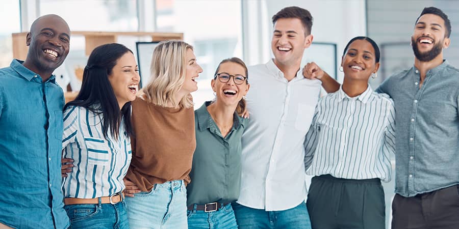 A group of diverse, middle-aged adults embracing eachother.