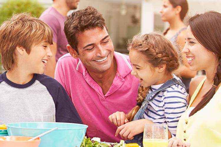 Family laughing and sitting at a table.