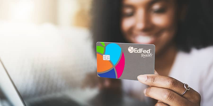 A woman holding the EdFed Rewards Visa Credit Card