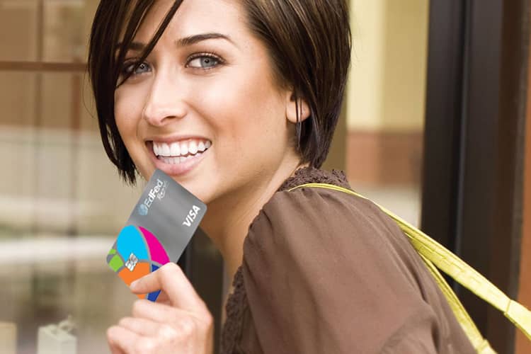 Woman smiling holding credit union credit card