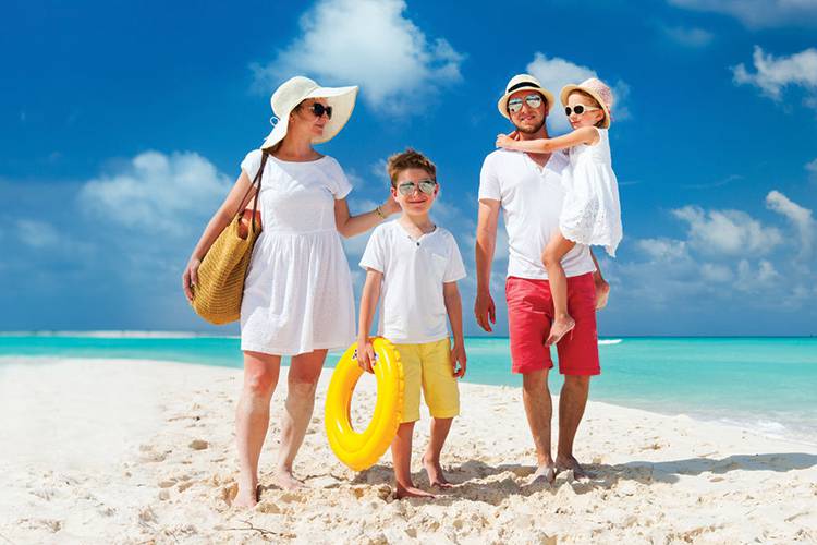 Family of four walking on the beach.