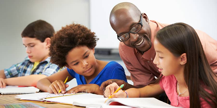 A teacher assisting young students.