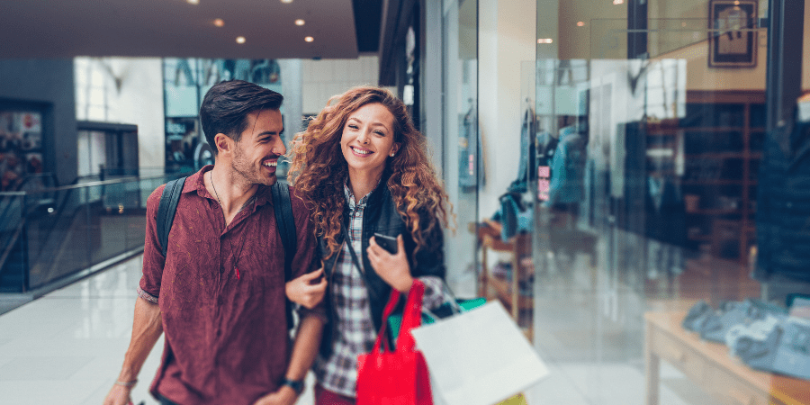 A young couple walking together in a mall.