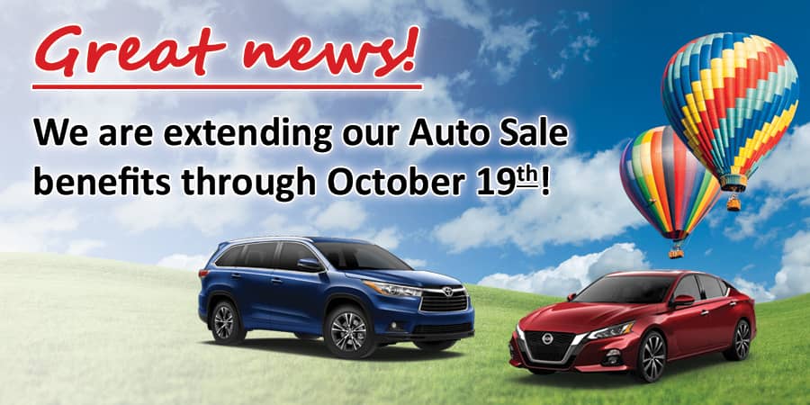 A red Honda Accord parked outside on a sunny day with huge colorful umbrellas floating around it and, above it, the words: BIG Savings Extended through May 5th!