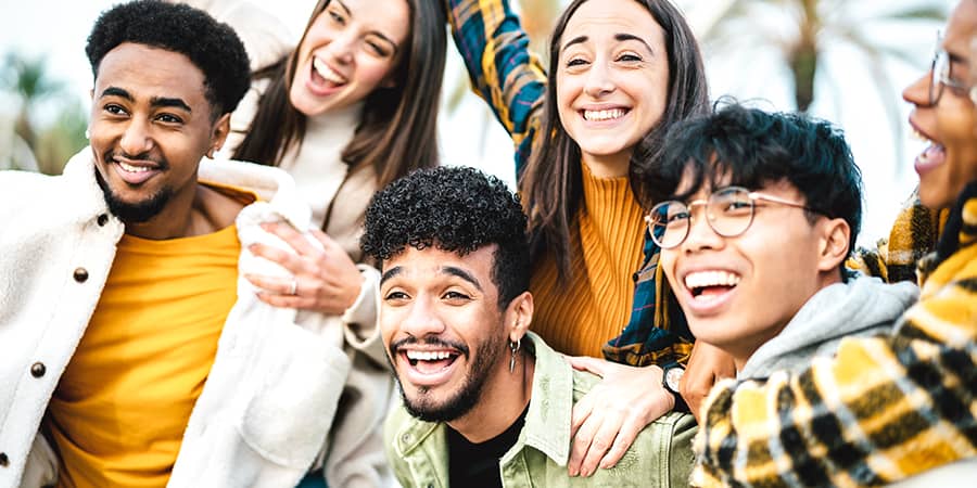 A group of young students together laughing.