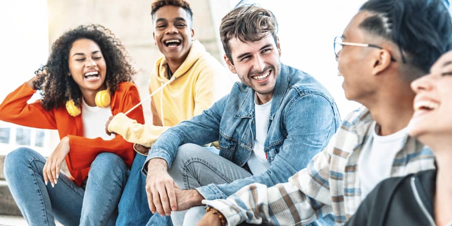 A group of young students sitting together laughing.
