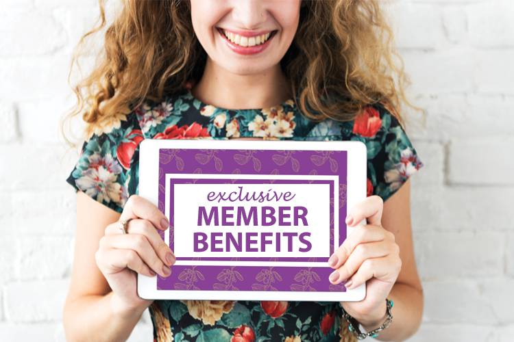 A woman smiling while holding a purple sign reading: Exclusive Member Benefits