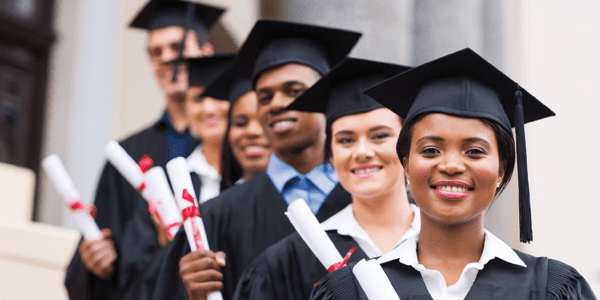 Students in a line wearing graduation gowns and caps.